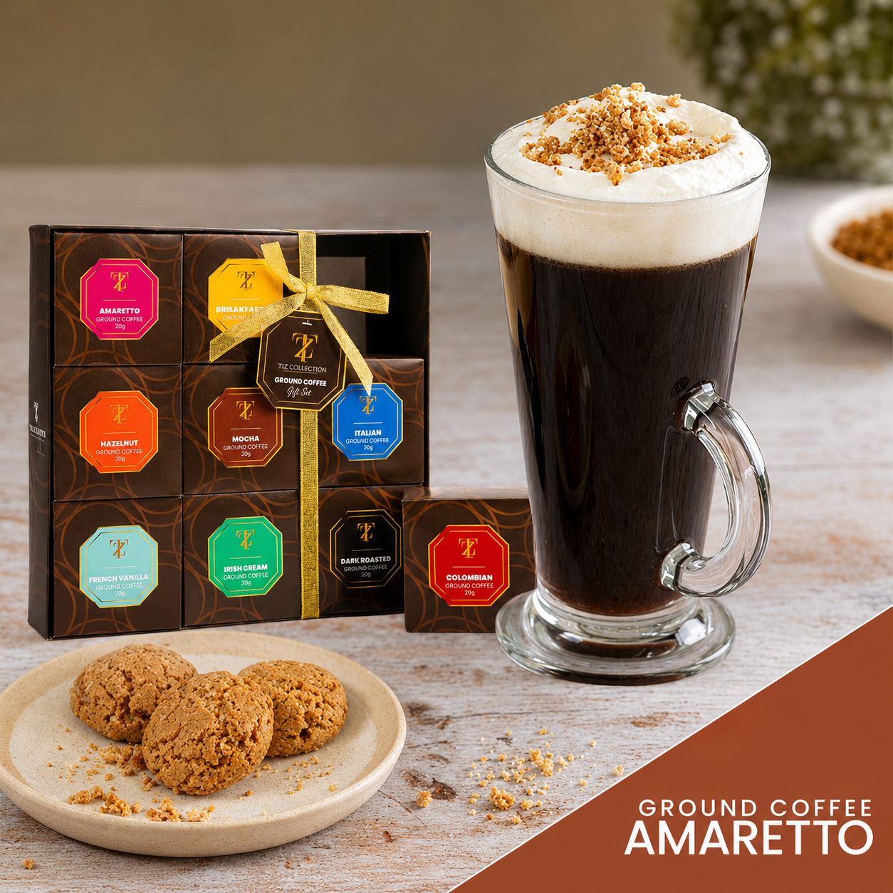 Tilz Collection Ground Coffee Gift Set featuring Amaretto ground coffee flavour with latte glass topped with whipped cream and cookies on wooden table alongside the 9-pack presentation box