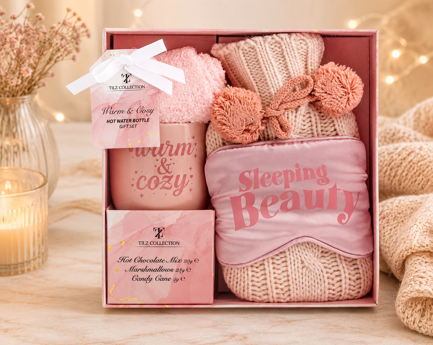 Tilz Collection Hot Water Bottle and Hot Chocolate Gift Box Blush Pink — front view of open pink gift box with hot water bottle, eye mask, cosy socks, hot chocolate mix and marshmallows