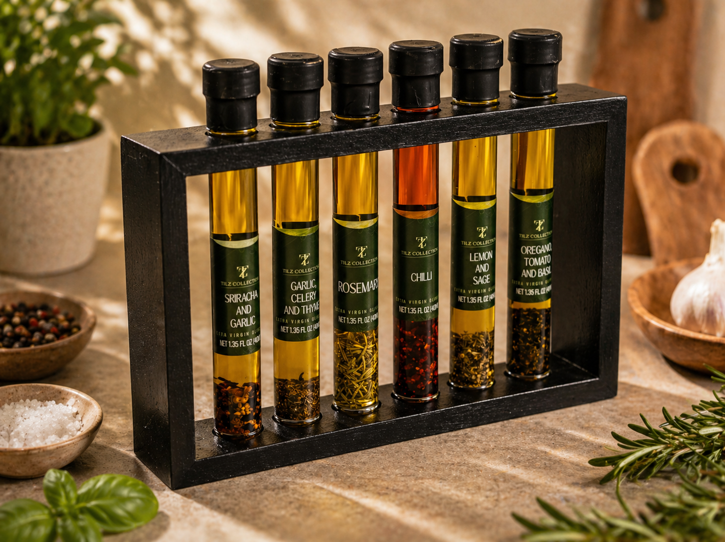 Tilz Collection Infused Oil Gift Set side view 6 gourmet cooking oils and balsamic blends in wooden display rack with oil pourer fresh herbs garlic and peppercorns on rustic kitchen surface