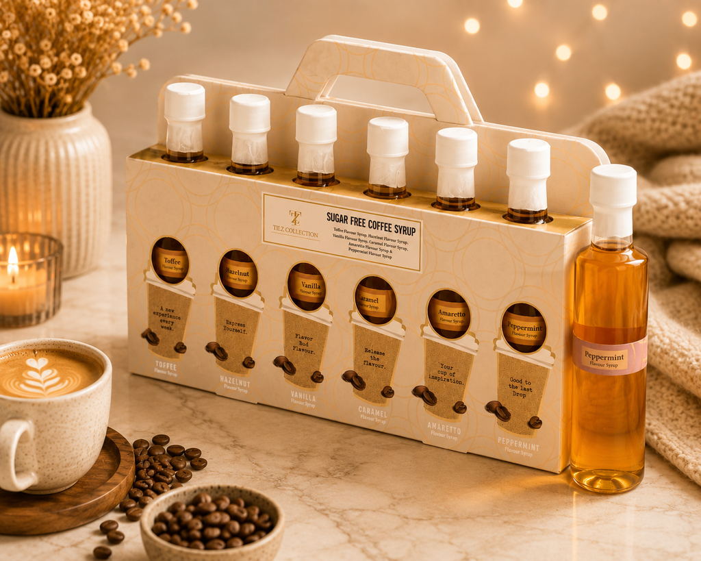 Tilz Collection Sugar Free Coffee Syrup Gift Set 6 cafe flavour bottles in carrier box angle view with latte coffee beans and candles on marble surface
